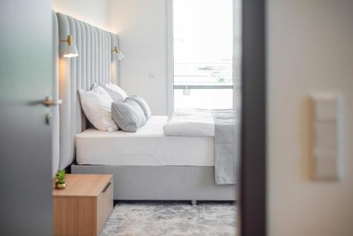 a bedroom with a bed with pillows and a window at BRIGHT: Rosenheim Aicherpark in Rosenheim