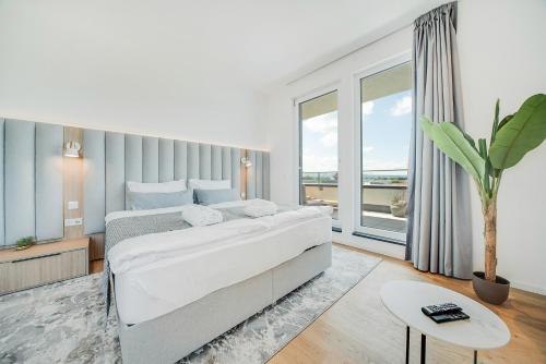 a bedroom with a large bed and a large window at BRIGHT: Rosenheim Aicherpark in Rosenheim