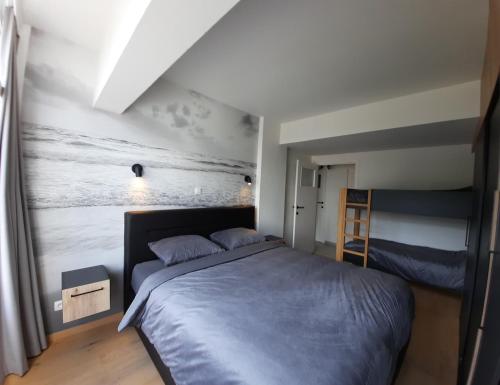 a bedroom with a bed and a painting on the wall at Lichtrijk en comfortabel hoekappartement met gratis parking en zeer centraal gelegen - Comme Chez Soi in Ostend