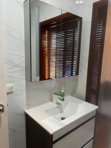 ein weißes Badezimmer mit einem Waschbecken und einem Spiegel in der Unterkunft Riverwood in Riverwood