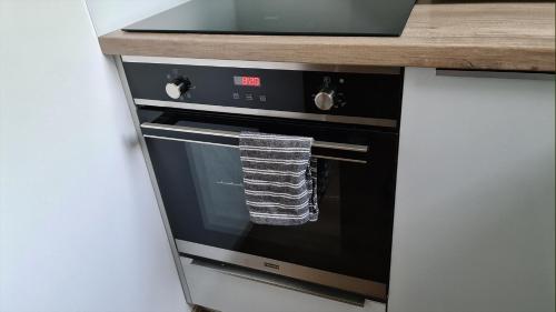 a kitchen oven with a towel hanging from it at Spokojny Wypoczynek 5 in Ostrów Wielkopolski