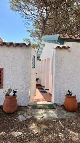 a white house with two large pots in front of it at Sweet home Santa Lucia in Santa Lucia