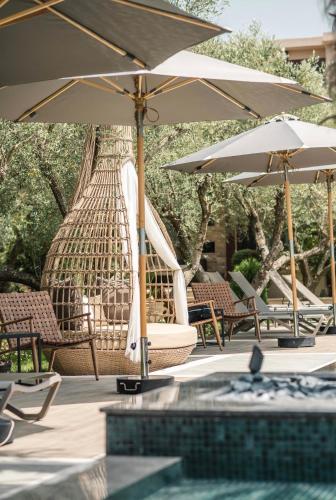 a group of chairs and umbrellas next to a pool at Giardino Lux Apartments in Ulcinj