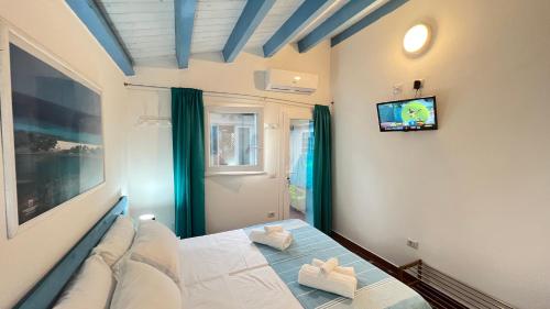 1 dormitorio con 1 cama y TV en la pared en Turquoise Sea House, en Santa Lucia
