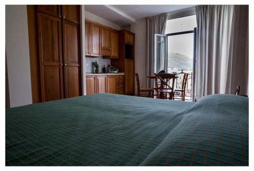 a bedroom with a bed with a green comforter at Lido Resort in Finale Ligure