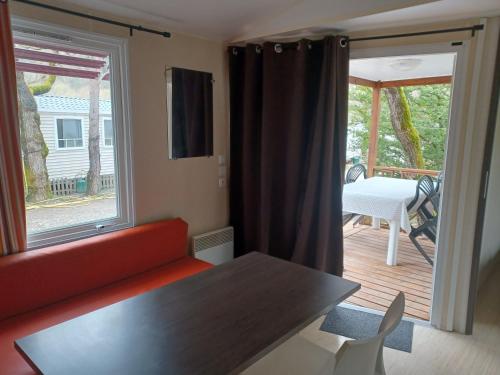 d'un salon avec un canapé et une table ainsi que d'une terrasse. dans l'établissement Les Acacias, à Vercheny