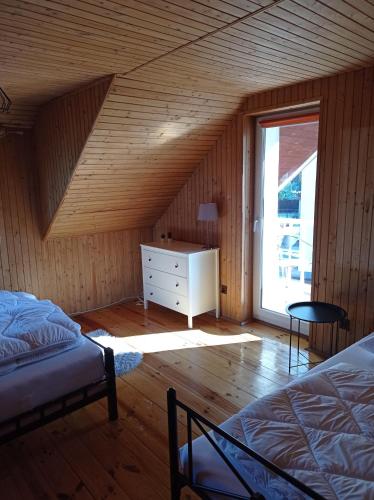 a bedroom with two beds and a dresser and a window at Żurawie Wzgórze in Mrągowo