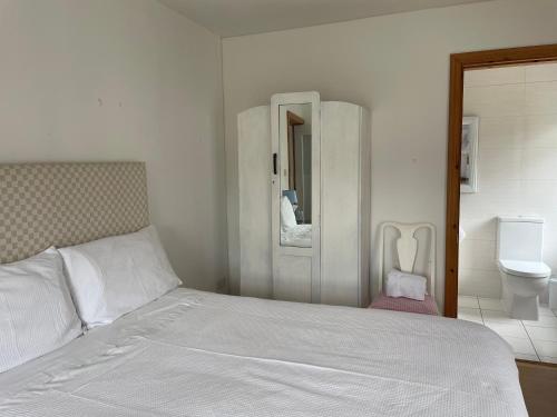 的住宿－Kerry Country House，一间白色卧室,配有床和卫生间
