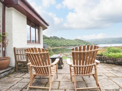 two chairs sitting on a porch with a view of a river at Allt An Dorran in Acharacle