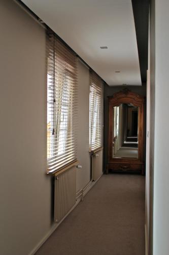 an empty hallway with two windows and a door at Hôtel L'Auberge Alsacienne in Eguisheim