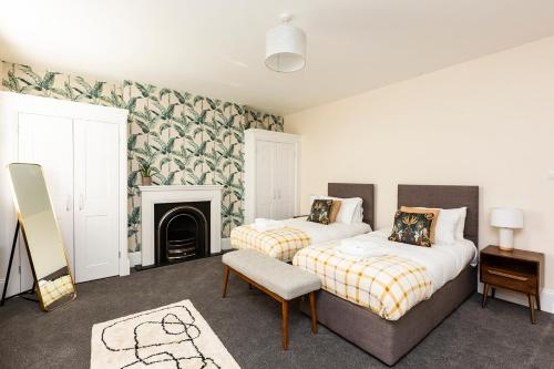 a bedroom with two beds and a fireplace at Stunning Seaside Apartment Over 3 Floors Near Margate in Westgate-on-Sea