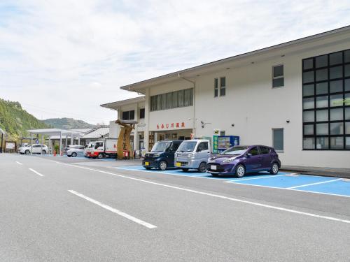 a parking lot with cars parked in front of a building at momijigawa onsen in Naka
