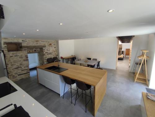 une cuisine avec un comptoir en bois et un îlot de cuisine dans l'établissement Conviviale - Longère Lumineuse - Charme & Nature, à Bains-sur-Oust