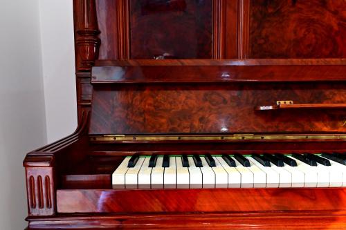 a wooden piano sitting next to a wall at Kore suites&apartments in Locri