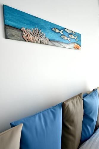 a painting on a wall above a couch at Kore suites&apartments in Locri