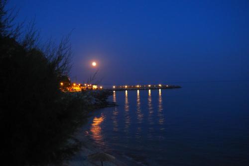 a moonrise over a body of water at night at Als Plomari - Sea View Apartment in Plomarion
