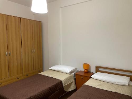 - une chambre avec deux lits et une armoire dans l'établissement Appartamento Marzamemi, à Marzamemi