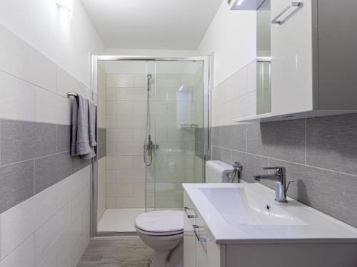 uma casa de banho com um chuveiro, um WC e um lavatório. em Merag Sunrise Apartment em Cres