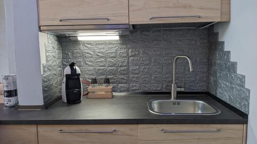 um balcão de cozinha com um lavatório e uma parede em IL Castelletto em Ortona