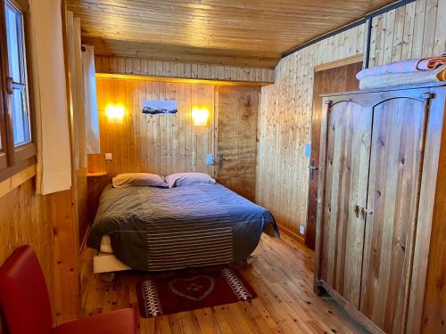ラ・クリュサにあるLa Clusaz Ski aux piedsの木製の壁のベッドルーム1室(ベッド1台付)