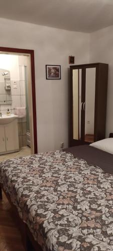 a bedroom with a bed and a bathroom with a sink at DVOKREVETNA SOBA SA KUPAONICOM in Vodice