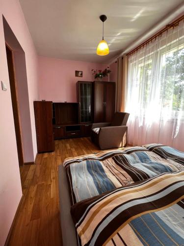 a bedroom with a bed and a chair and a window at Apartament Rodzinny in Rumia