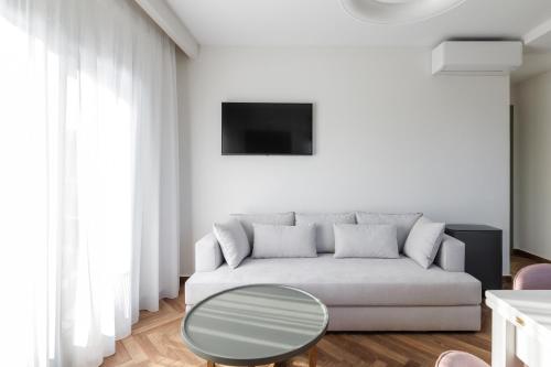 a white living room with a couch and a table at Helia All Seasons Apartments in Astris