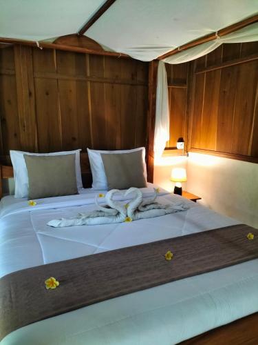 a large white bed with a towel on it at Friendly Homestay Lemukih in Singaraja