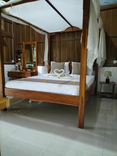 a bedroom with a large wooden bed in a room at Friendly Homestay Lemukih in Singaraja