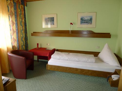 a bedroom with a bed and a table and a chair at Landhaus Schoenen in Sasbachwalden