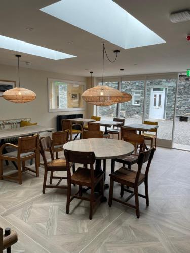 a dining room with tables and chairs and lights at Royal Oak Hotel in Rosthwaite