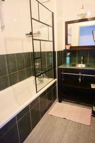 a bathroom with a bath tub and a sink at Superbe appartement avec piscine in Aureilhan