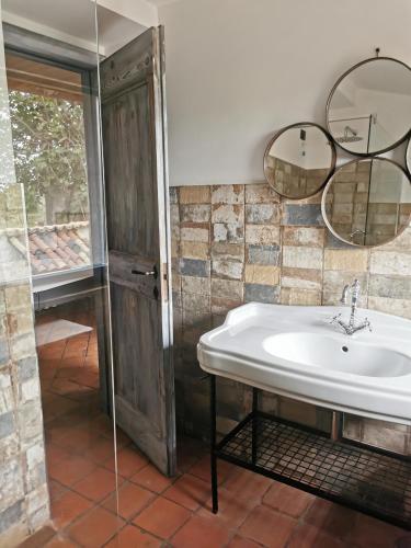 a bathroom with a sink and two mirrors at Domus Nirale in Bagnoregio