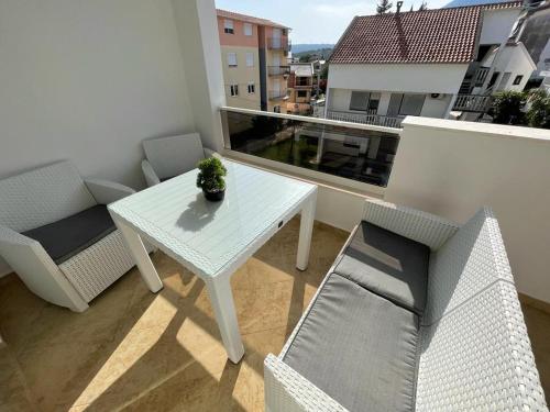 a small balcony with a table and chairs on a building at Apartments Pericic in Sutomore