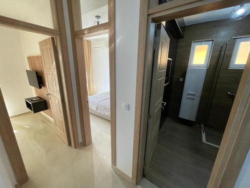a hallway with a room with a bed and a mirror at Apartments Pericic in Sutomore