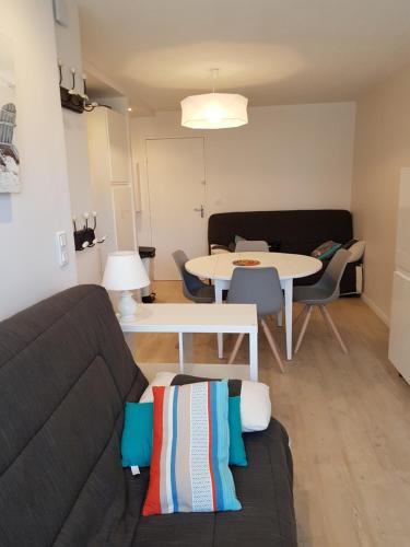 ein Wohnzimmer mit einem Sofa und einem Tisch in der Unterkunft appartement à 300m de la plage in Saint-Georges-de-Didonne