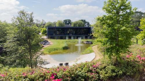 a building with a pond and a fountain at La Marquise luxe vakantiehuis in Budel