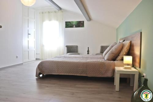 ein Schlafzimmer mit einem Bett und einem Tisch mit einer Lampe in der Unterkunft au gite de la cascade in Le Grand Serre