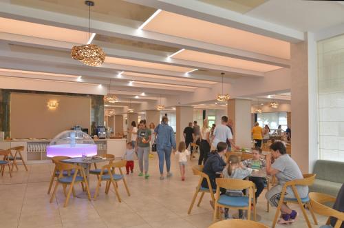 a rendering of the lobby of a restaurant with people sitting at tables at Hotel Opal in Jupiter