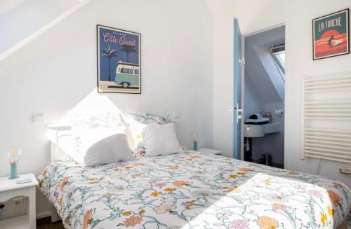 a bedroom with a bed with a floral bedspread at CAP COZ Sea Side FOUESNANT in Fouesnant
