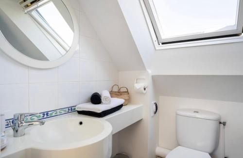 a white bathroom with a sink and a mirror at CAP COZ Sea Side FOUESNANT in Fouesnant