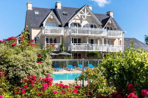 une grande maison avec une piscine et des fleurs dans l'établissement CAP COZ Sea Side FOUESNANT, à Fouesnant