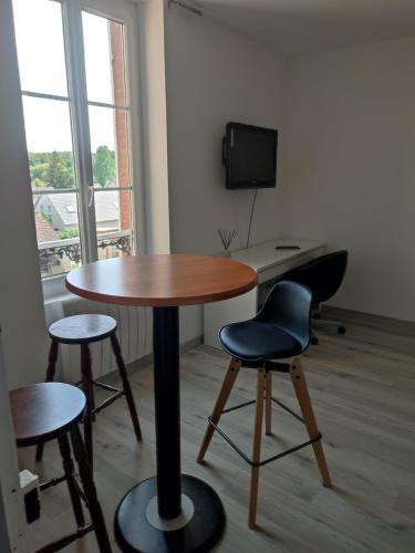 una camera con tavolo e due sedie e una scrivania di La maison fleurie 2 a Sainte-Geneviève-lès-Gasny