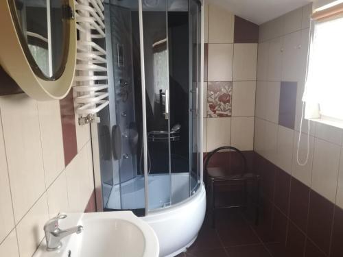 a bathroom with a shower and a sink and a mirror at Apartament 2pokojowy 4-5osobowy in Węgorzewo