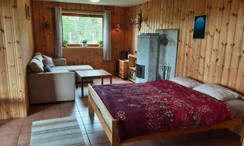 a bedroom with a bed and a couch and a table at Casa San Gottardo - The Forest House, Etnedal in Etnedal