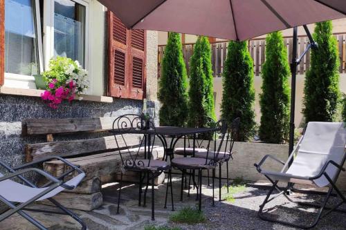 a table and chairs and an umbrella on a patio at Baita Carmen Bormio in Bormio