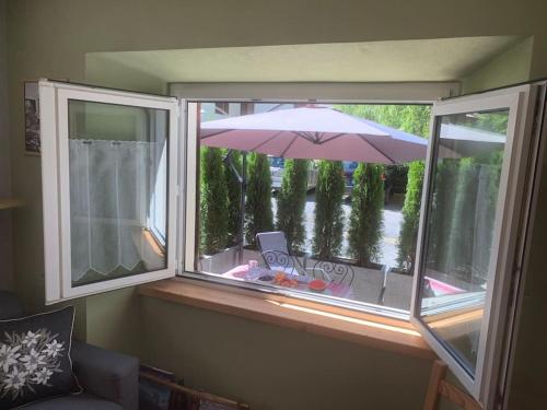 a window with an umbrella in a room with a table at Baita Carmen Bormio in Bormio