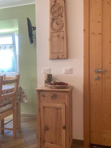 a room with a wooden table and a clock on the wall at Baita Carmen Bormio in Bormio