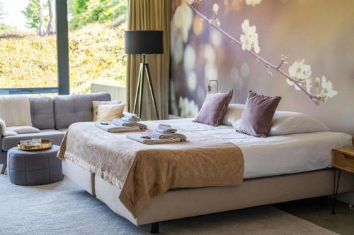 a bedroom with a bed and a couch at La Marquise luxe vakantiehuis in Budel