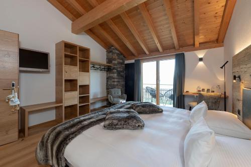 a bedroom with a large white bed in a room at Berghotel Tgantieni in Lenzerheide